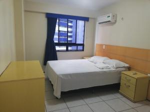 Apartamento em Fortaleza في فورتاليزا: غرفة نوم صغيرة بها سرير ونافذة