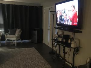 uma sala de estar com uma televisão de ecrã plano num suporte em Long Lake Waterfront Bed and Breakfast em Nanaimo
