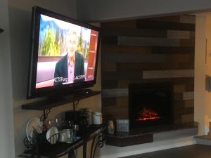 TV en la sala de estar con chimenea en Long Lake Waterfront Bed and Breakfast, en Nanaimo
