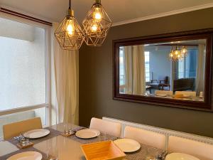 uma sala de jantar com uma mesa e um espelho grande em La Serena Laguna del Mar hasta 8 personas espectacular departamento em La Serena