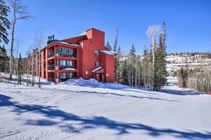 a large red building in the snow with trees at Brian Head Ski-InandSki-Out Condo with Resort Perks! in Brian Head