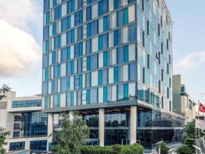 un edificio de oficinas de cristal alto con ventanas azules en Mercure Istanbul Umraniye, en Estambul