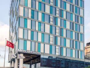 un gran edificio con una bandera delante de él en Mercure Istanbul Umraniye, en Estambul