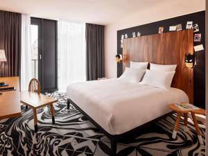 貝爾格勒的住宿－貝爾格萊德媽媽斯爾特旅館，酒店客房设有一张大床和一张书桌。