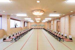 una sala de banquetes vacía con sillas, mesas y una lámpara de araña en Hita Onsen Kizantei Hotel en Hita