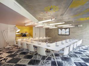 une salle de conférence avec une grande table et des chaises blanches dans l'établissement Mama Shelter Marseille, à Marseille