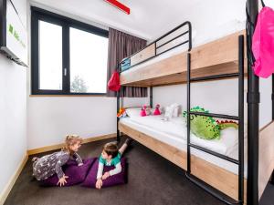 ブダペストにあるibis Styles Budapest Citywestの二段ベッドルームの床に横たわる子供2名