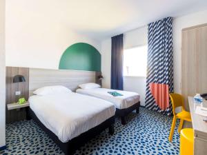 a hotel room with two beds and a desk at ibis Styles Marseille Plan de Campagne in Les-Pennes-Mirabeau +86 photos