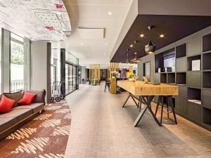 a living room with a couch and a table at ibis Baden Neuenhof in Baden