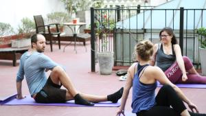 three people sitting on mats in a yoga class at Voyage Recoleta Hostel in Buenos Aires