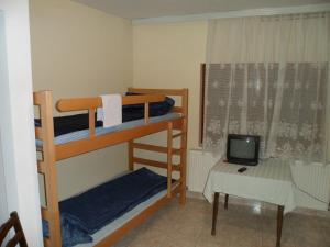 a bedroom with two bunk beds and a small television at Hostel Olimpik in Negotin