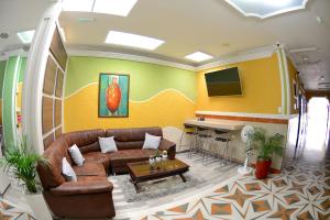a living room with a couch and a tv at La Hermosa Hotel in Buga