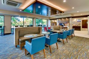 菲什基尔Holiday Inn Express Fishkill-Mid Hudson Valley by IHG的酒店大堂设有桌子和蓝色椅子。