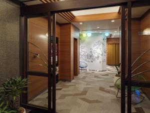 an office corridor with a glass door and plants at KOKO HOTEL Ikebukuro East in Tokyo