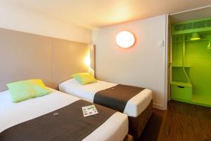 2 camas en una habitación de hotel con detalles verdes en Campanile Tours Sud ~ Joué-Les-Tours, en Joué-lès-Tours
