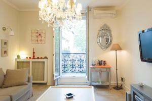 een woonkamer met een bank en een kroonluchter bij Appartement Canourgue - Première Conciergerie in Montpellier