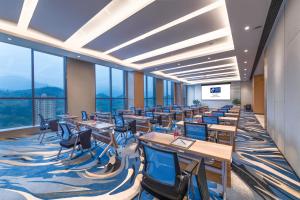 Una sala de conferencias con mesas, sillas y ventanas. en Holiday Inn Express Chongqing Zhongxian by IHG, en Zhongzhou