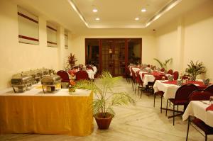 a banquet hall with tables and chairs in a room at The Golden Park in Madurai