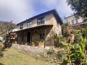 una casa in pietra con piante in vaso di fronte di Siddhartha Garden Ayurveda a Pokhara