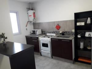 a kitchen with a stove and a sink in it at Costanera.VM in Villa María +22 photos