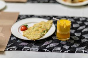 a plate of food and a glass of orange juice at Hotel Luciya in Cochin