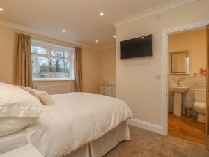 a bedroom with a bed and a television on a wall at Westholme in Barnard Castle