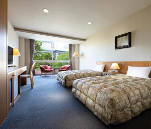 una camera d'albergo con due letti e una finestra di The Gran Resort Arima a Kobe