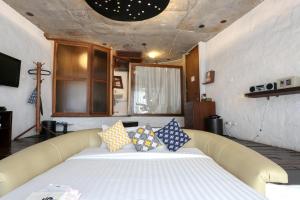 a large bed with pillows on it in a room at Mo rooms in Chiang Mai