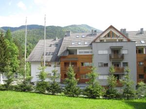 ein großes Haus mit einem Berg im Hintergrund in der Unterkunft Apartments Plan Kranjska Gora in Kranjska Gora