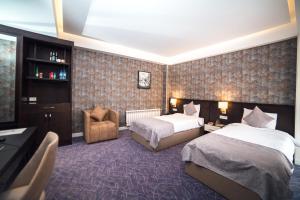 Parkway Inn Hotel & Spa في باكو: غرفة فندقية بسريرين وكرسي