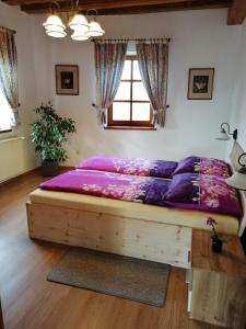 um quarto com uma cama grande e lençóis roxos em Ferienwohnung Michlwirt em Bad Radkersburg