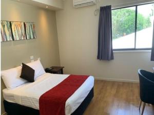 um quarto de hotel com uma cama e uma janela em Weipa Motel Resort em Weipa