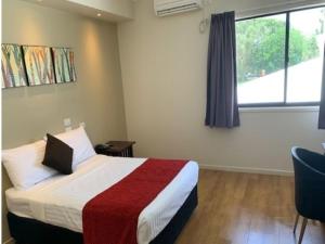 une chambre d'hôtel avec un lit et une fenêtre dans l'établissement Weipa Motel Resort, à Weipa