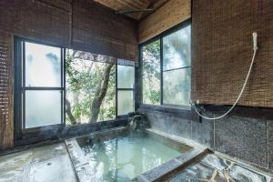 Habitación con piscina de agua y ventanas en Chojuyu Hakone, en Hakone