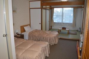 ein Hotelzimmer mit zwei Betten und einem Fenster in der Unterkunft The Gran Resort Elegante Karuizawa in Karuizawa + 37 Fotos