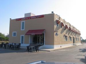 a building with tables and chairs in front of it at Hostal Imperial in Crevillente