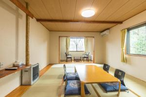 ein Wohnzimmer mit einem Holztisch und Stühlen in der Unterkunft Chojuyu Hakone in Hakone