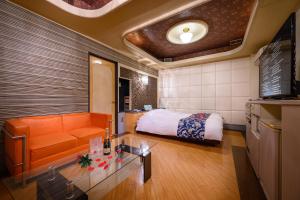 um quarto de hotel com uma cama e um sofá em HOTEL MOBILIA (Adult Only) em Tsurugashima