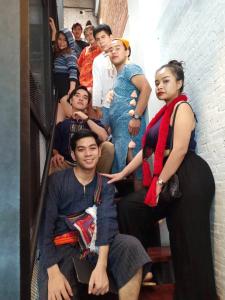 een groep mensen die op een trap zitten bij Yindee Travellers Lodge in Nan