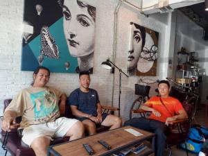 tres personas sentadas en un sofá en una habitación en Yindee Travellers Lodge en Nan
