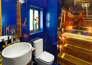 Baño azul con aseo y lavamanos en Tanjore Hi Hotel, en Thanjāvūr