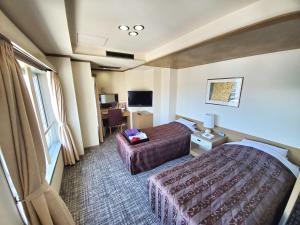 a hotel room with two beds and a television at The Gran Resort Elegante Kyoto in Kyoto