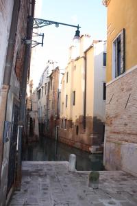 een steegje met een kanaal in een stad met gebouwen bij Venice Boutique House in Venetië