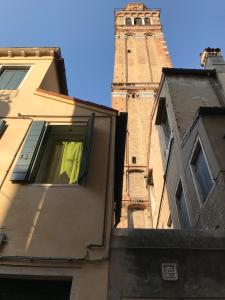 een gebouw met een klokkentoren op de achtergrond bij Venice Boutique House in Venetië