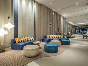 um átrio com sofás azuis, mesas e cadeiras em Mercure Pattaya Ocean Resort em Pattaya Central
