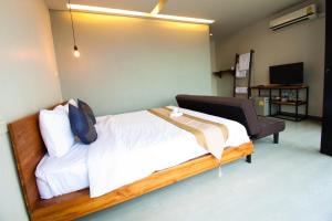 a bedroom with a large bed and a chair at 3 Laan House in Chiang Mai