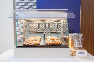 a display of donuts in a display case at Holiday Inn Express & Suites Mississauga-Toronto Southwest, an IHG Hotel in Mississauga