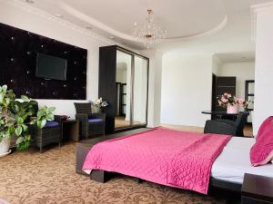 1 dormitorio con cama rosa y espejo en ArkPalmira en Odesa