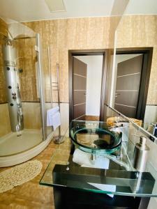 a bathroom with a glass sink and a shower at ArkPalmira in Odesa