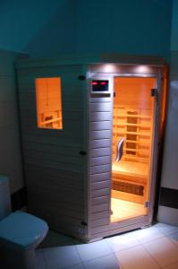 a small refrigerator in a bathroom with a toilet at Penzion u můstku Jiřího Rašky in Trojanovice